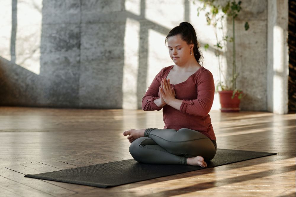 Frau sitzt auf Yogamatte und meditiert