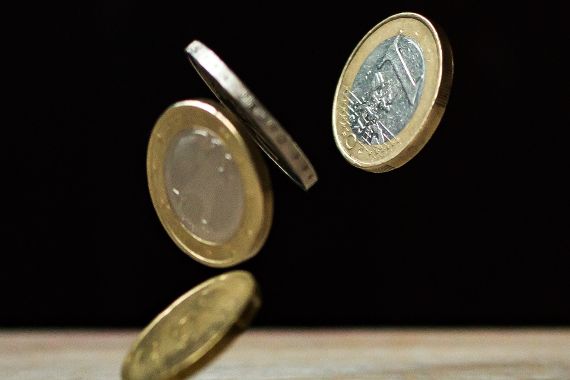 Euromünzen fallen auf einen Tisch